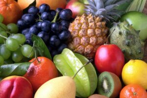 Variedad de frutas frescas con piña, uvas, kiwi, carambola, naranjas y kiwano