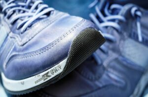 Primer plano de zapatillas deportivas azules con puntera reforzada y cordones