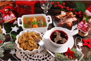 Platos típicos de cena navideña con sopa de remolacha, bigos y caldo, rodeados de adornos festivos
