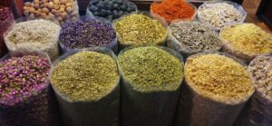 Sacos abiertos con hierbas secas, flores, especias y resinas de colores en un mercado
