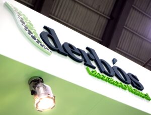 Rótulo corporativo de Derbós Laboratorio Natural iluminado con foco en un stand de feria