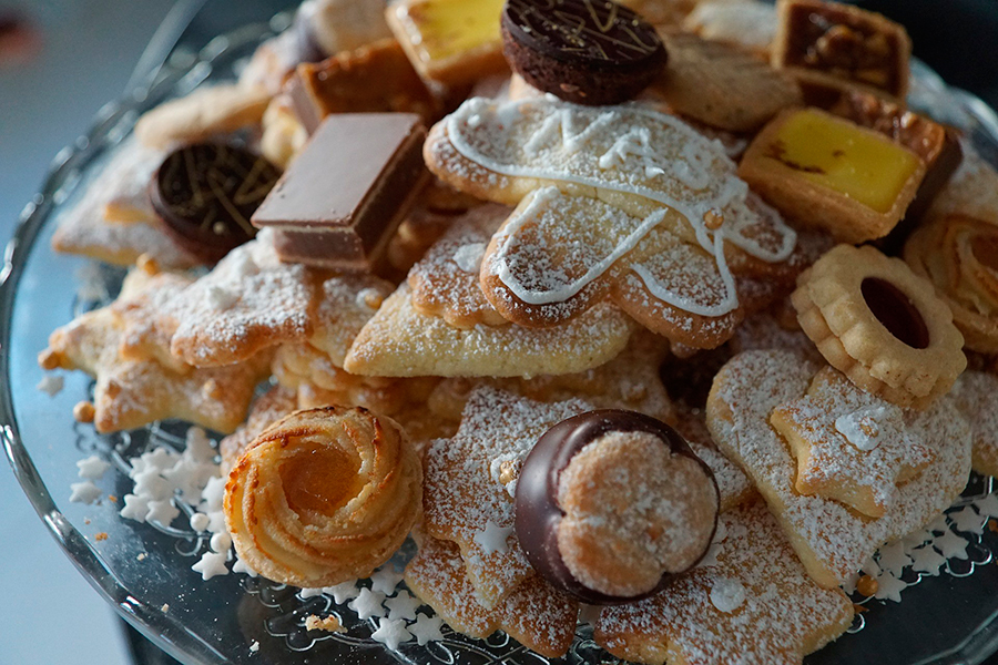 Bandeja de cristal con surtido de galletas navideñas y pastas de té espolvoreadas con azúcar y chocolate