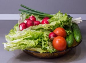 Fuente con verduras frescas: lechuga, rábanos, tomates, pepinos y cebolletas