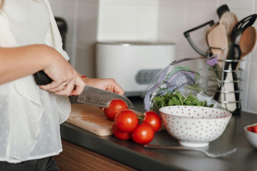mujer cortando tomate