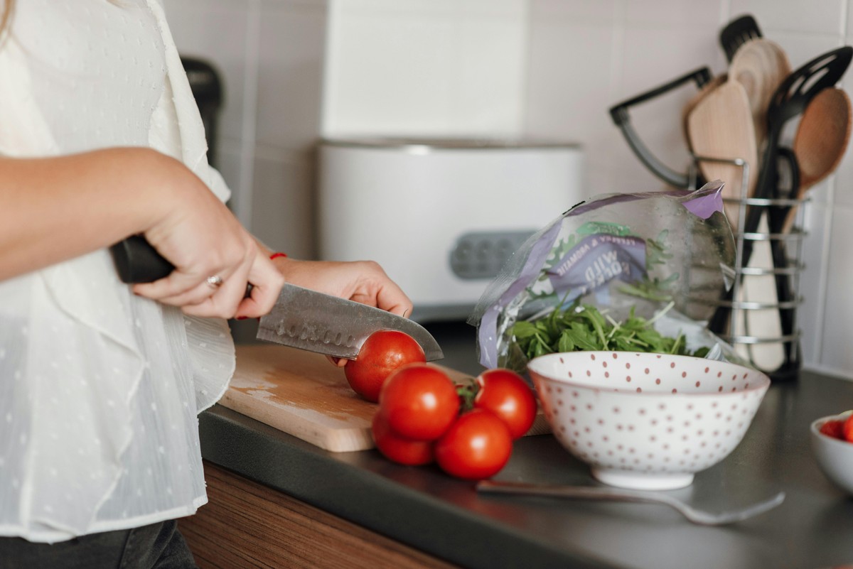 mujer cortando tomate