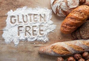 Día de la enfermedad Celiaca - Vista de una mesa con panes de todo tipo y un cartel de Gluten Free