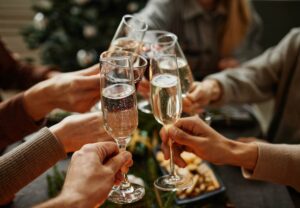 Personas brindando con copas de cava en una celebración navideña.