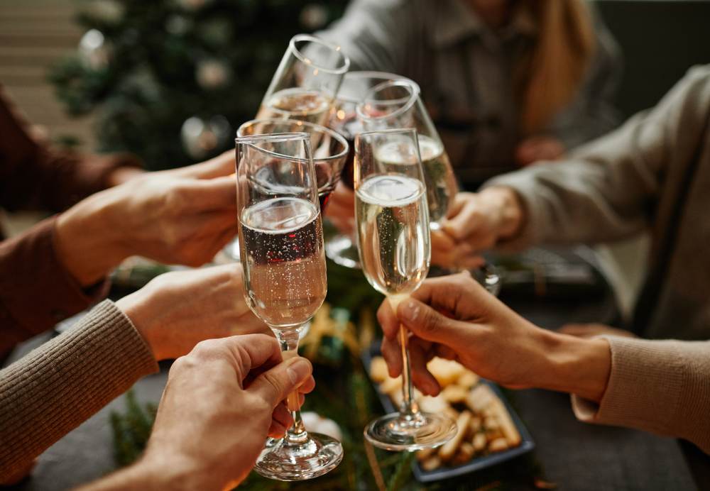 Personas brindando con copas de cava en una celebración navideña.