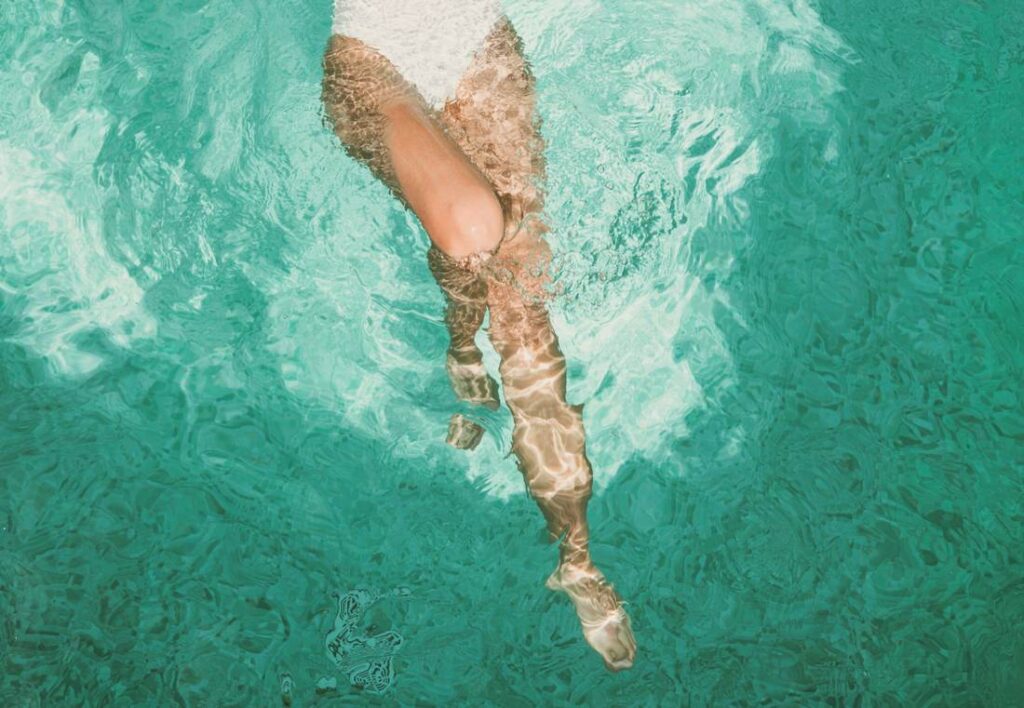 Mujer nadando en una piscina en verano