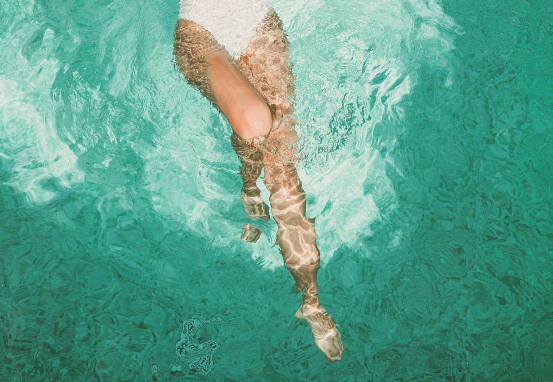Mujer nadando en una piscina en verano