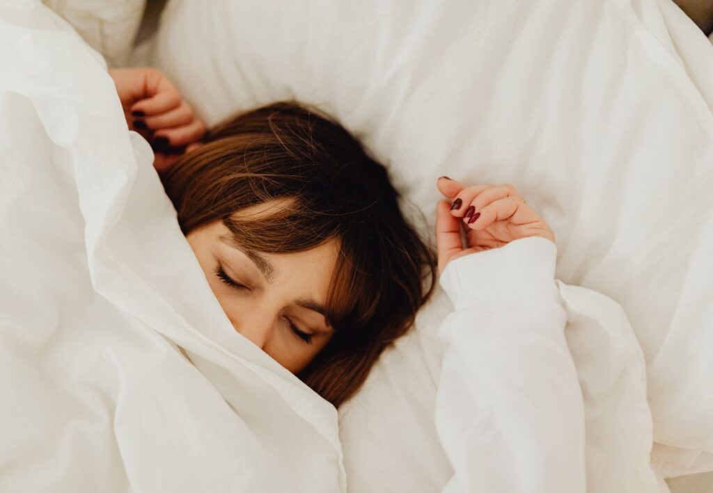 Mujer descansando en la cama representando el equilibrio emocional y el bienestar mental