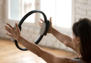 Mujer practicando pilates con aro para mantener el bienestar óseo y muscular
