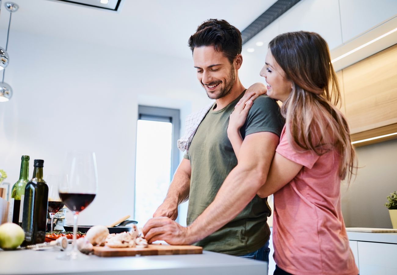 Pareja cocinando juntos de forma saludable en una cocina luminosa