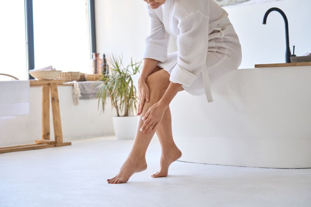 Mujer aplicándose gel efecto frío para aliviar las piernas cansadas en verano